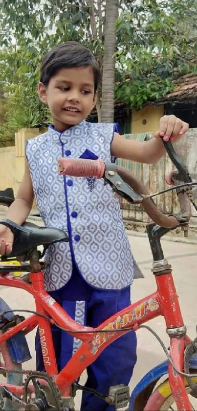 Smiling child with a bicycle outdoors, wearing colorful clothing.