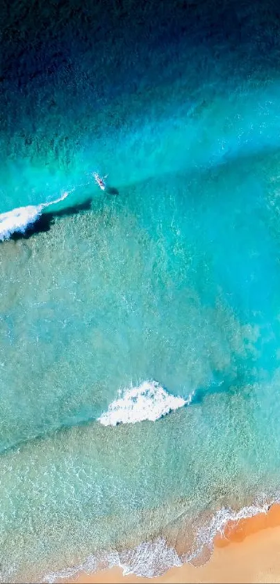 Aerial view of turquoise ocean waves meeting golden sandy beach.