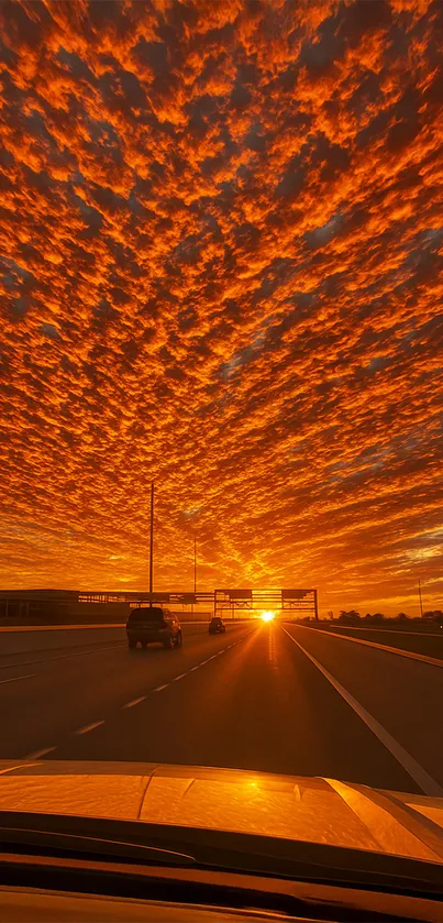 Fiery sunset over highway with orange sky.