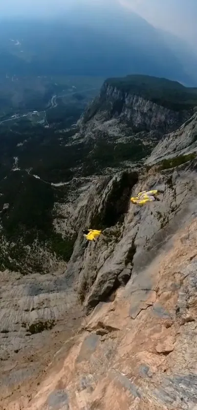 A stunning mountain landscape with wingsuit flyers diving off a rocky cliff.