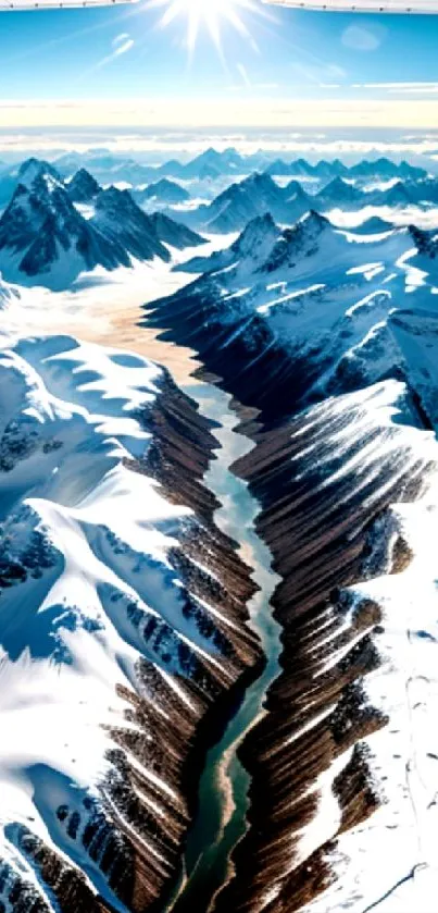 Aerial view of snow-capped mountains with a winding river under a clear blue sky.