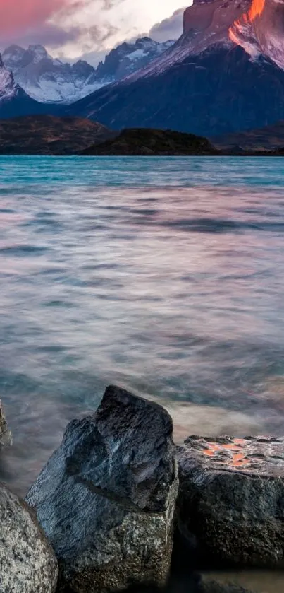 Mountain lake with rocks and sunset sky.