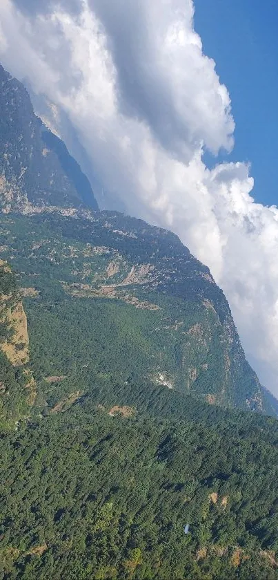 Mountain landscape with blue sky and clouds, lush green valleys.