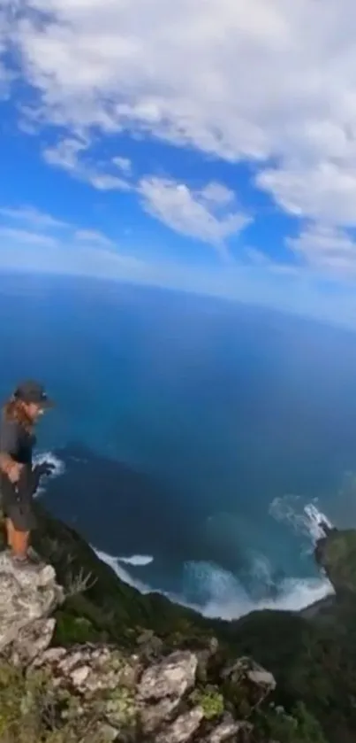 Person standing on cliff overlooking vast ocean and sky.