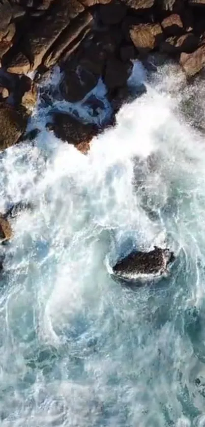 Aerial view of ocean waves crashing against rocky shoreline.