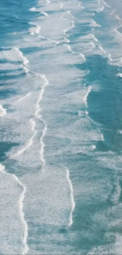 Aerial view of ocean waves crashing on a sandy beach, creating a soothing pattern.