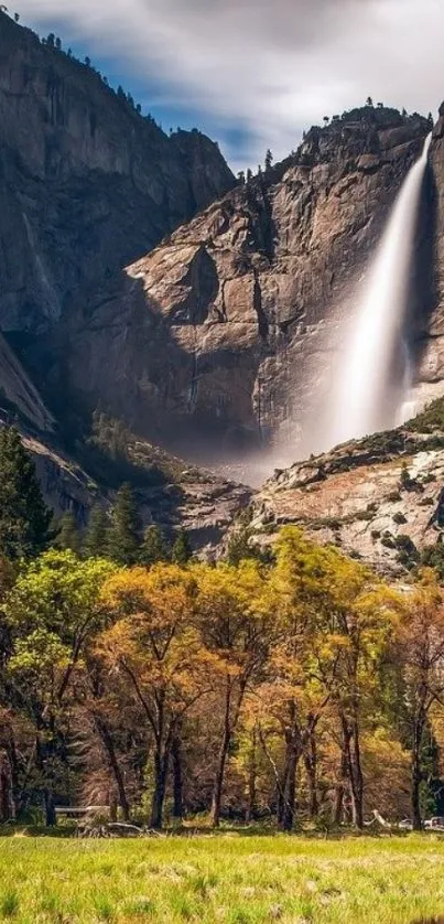 Stunning waterfall cascading down rocky cliffs into a lush green meadow.