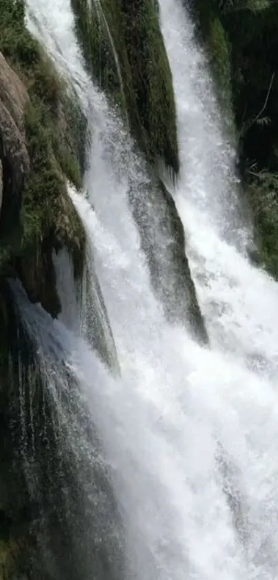 Mobile wallpaper of a cascading waterfall with lush greenery.