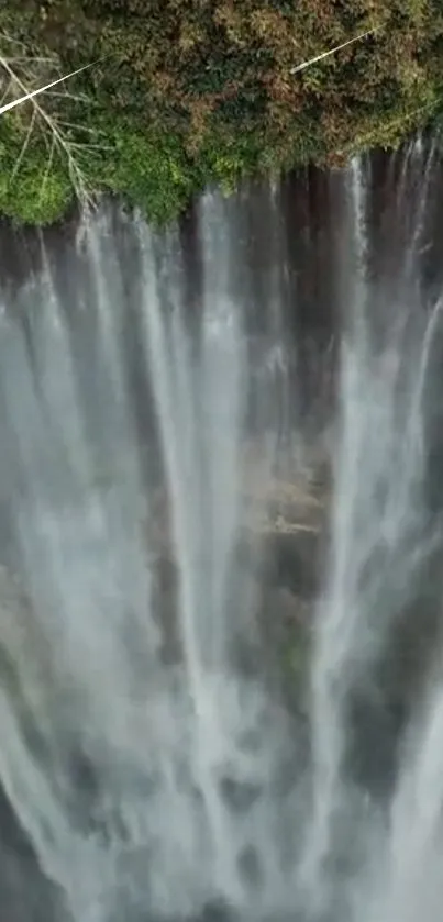 Aerial view of a majestic waterfall surrounded by lush green foliage.