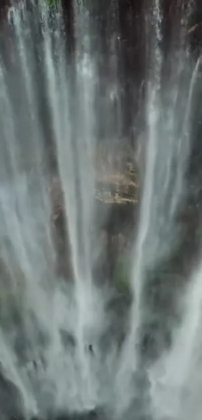 Serene waterfall cascading down rocks in a beautiful natural setting.