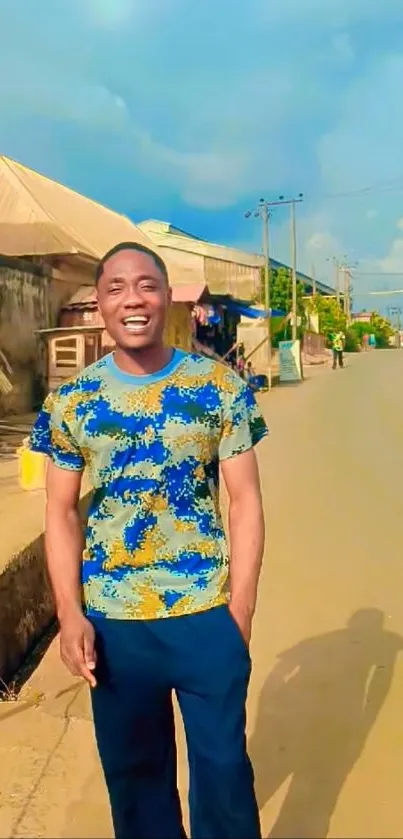 Man smiling on a sunny street with vibrant background.