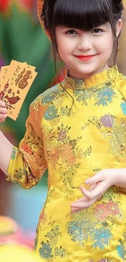 Child in vibrant traditional yellow attire holding envelopes.