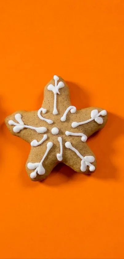 Star-shaped gingerbread cookie with icing on an orange background.