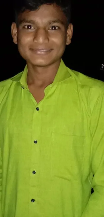 Young man in lime green shirt against dark background.