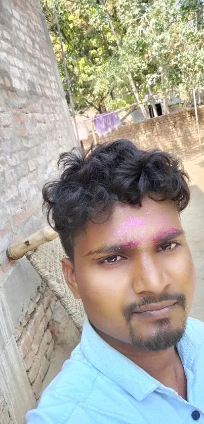 A young man with colorful face under a bright blue sky.