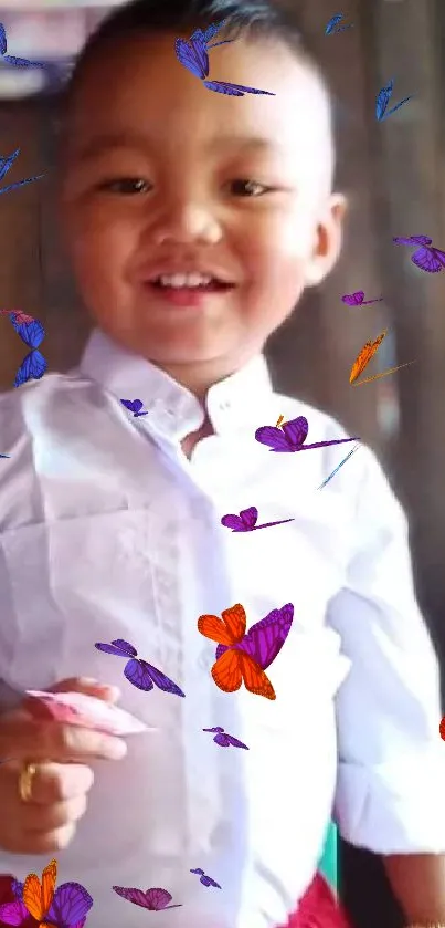 A young child smiling in a white shirt with a joyful expression.