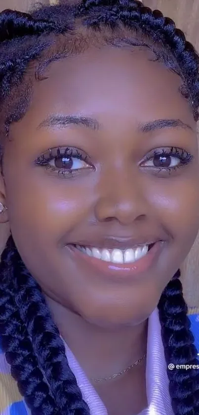 Smiling person with braided hair on wallpaper.