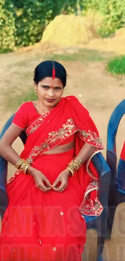 Woman in traditional red attire sitting outdoors.