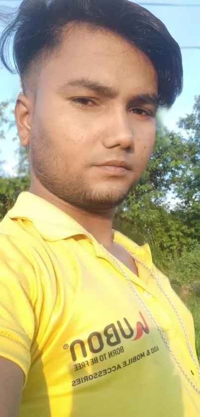 Person in a bright yellow shirt with a green nature background.