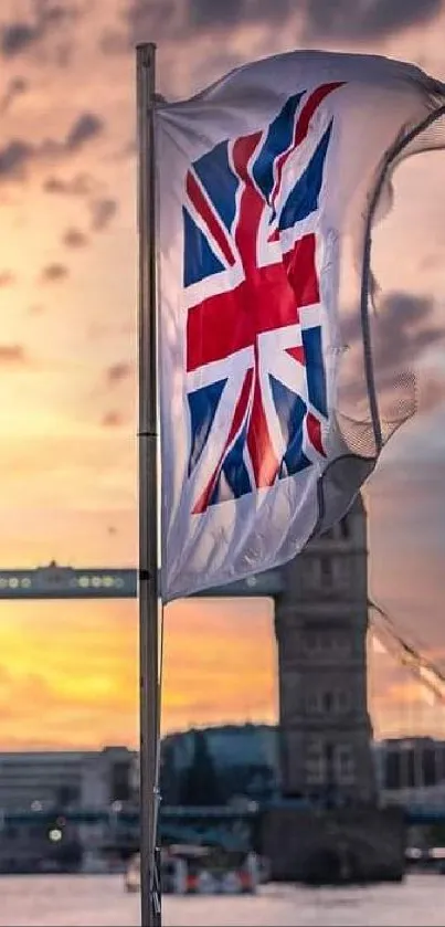 Union Jack waving at sunset in front of Tower Bridge.