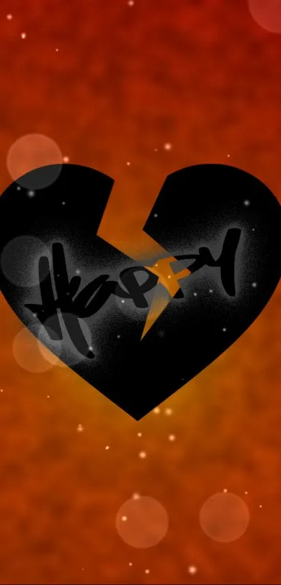 Abstract wallpaper with a black broken heart on an orange bokeh background.