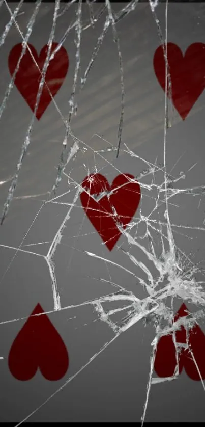 Shattered playing card with red hearts on a gray background.