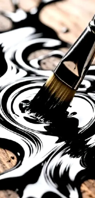 Close-up of a brush creating black swirl patterns on a surface.