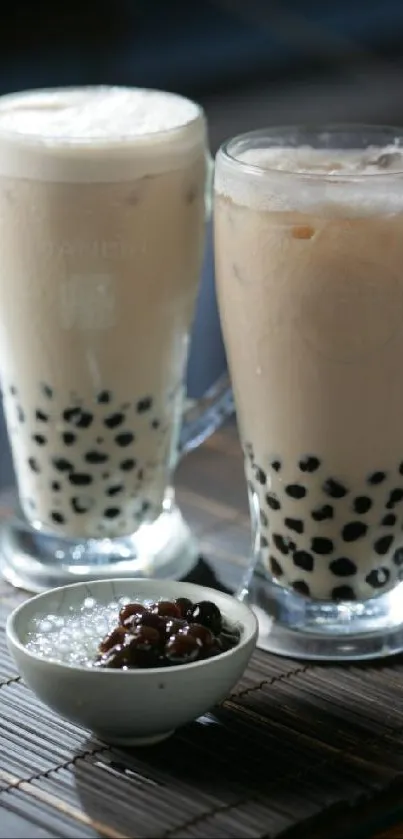 Two glasses of delicious bubble tea with tapioca pearls on a wooden mat.