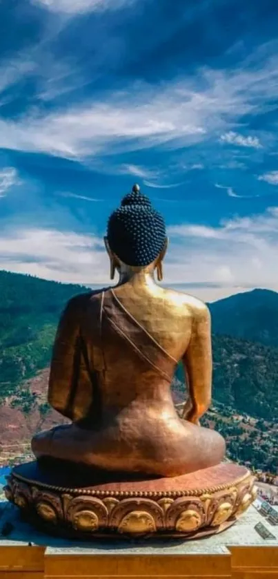 Golden Buddha statue with mountain backdrop and blue sky.