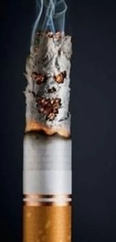 Close-up of a burning cigarette with ash and smoke on a dark background.