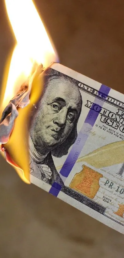 A burning hundred-dollar bill with flames and smoke.