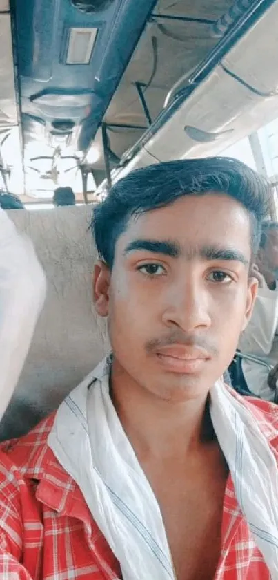 Young man on a bus, capturing a travel moment.