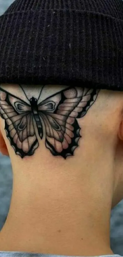 Stylish butterfly tattoo on neck with a black cap.