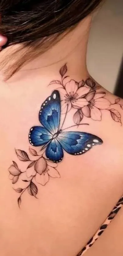 Blue butterfly tattoo with floral design on shoulder.