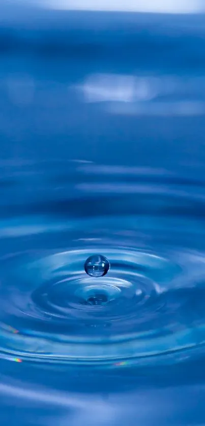 Close-up of a blue water ripple with a droplet at the center, creating a calming design.
