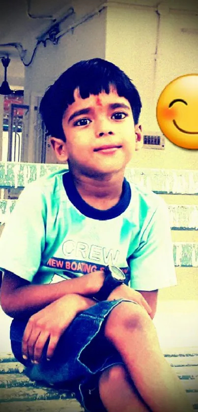 Young boy sitting on a blue bench with a smiley face emoji.