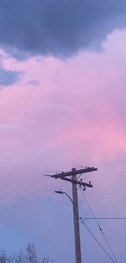 Calm pink and blue evening sky wallpaper with clouds and a wooden pole.