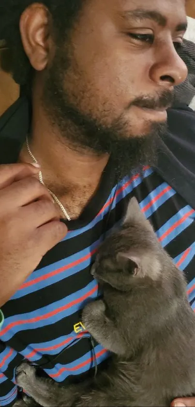 Man relaxing with a kitten sleeping on his chest.