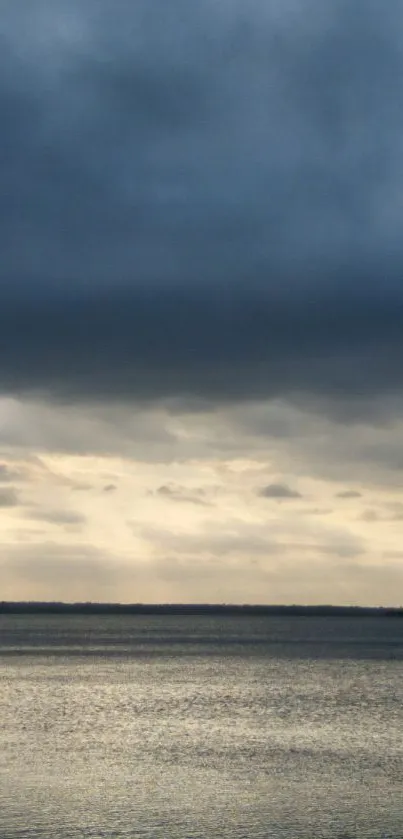 Tranquil ocean view under a moody dusk sky.