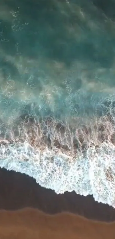 Aerial view of ocean waves crashing on a sandy beach.