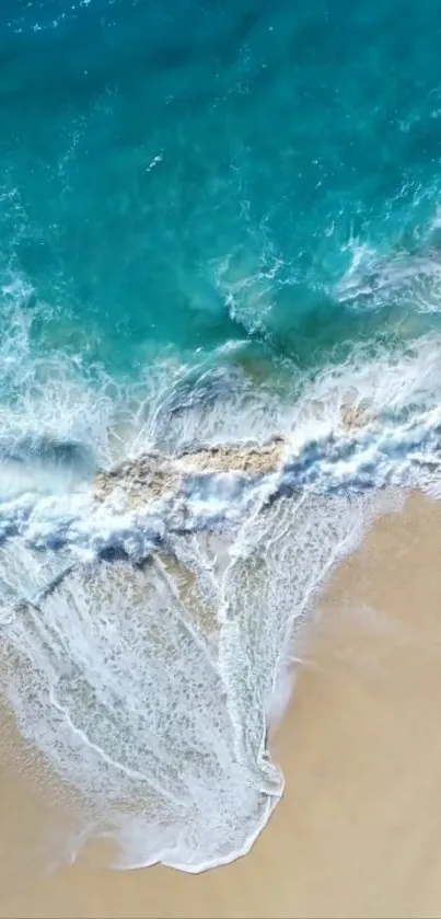 Aerial view of ocean waves meeting sandy beach