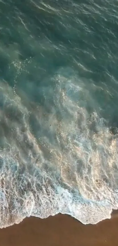 Aerial view of calming ocean waves on a sandy beach for mobile wallpaper.