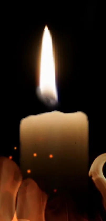 Candle flame on dark background wallpaper for mobile phone.