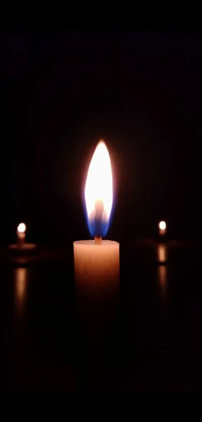 Candlelight glowing in the darkness mobile wallpaper.