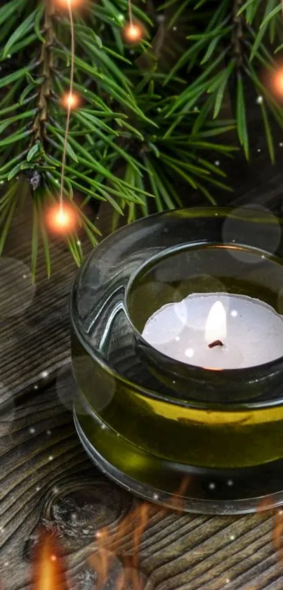 Candle with pine branches on wooden surface, glowing warmly.