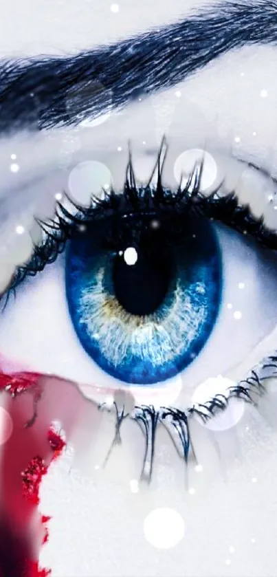 Artistic blue eye with red accents and snowflakes on a phone wallpaper.