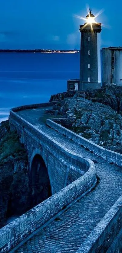 Scenic night view of lighthouse with cobbled path leading to the shore.