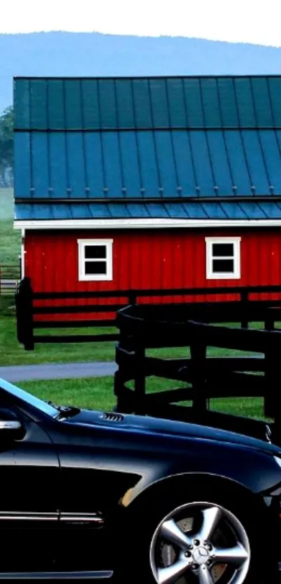 Black car parked near a red barn in a countryside setting.