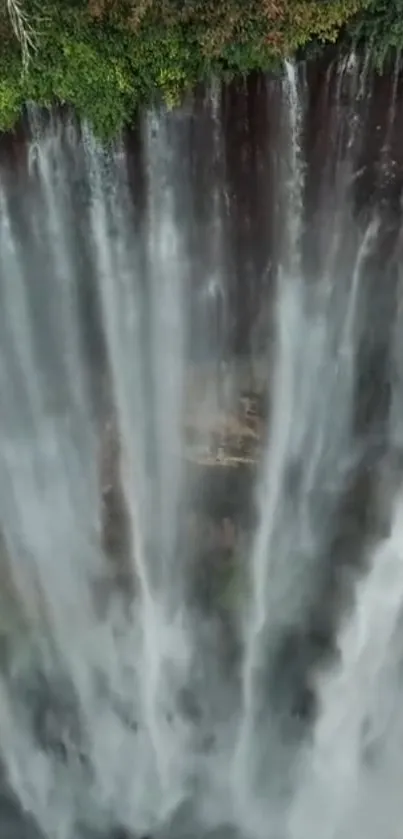 Aerial view of a vibrant cascading waterfall with lush greenery.