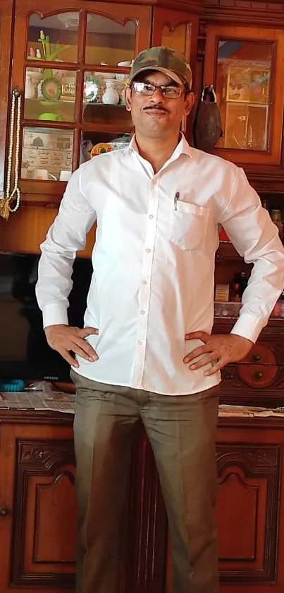 Man in casual attire with wooden backdrop.